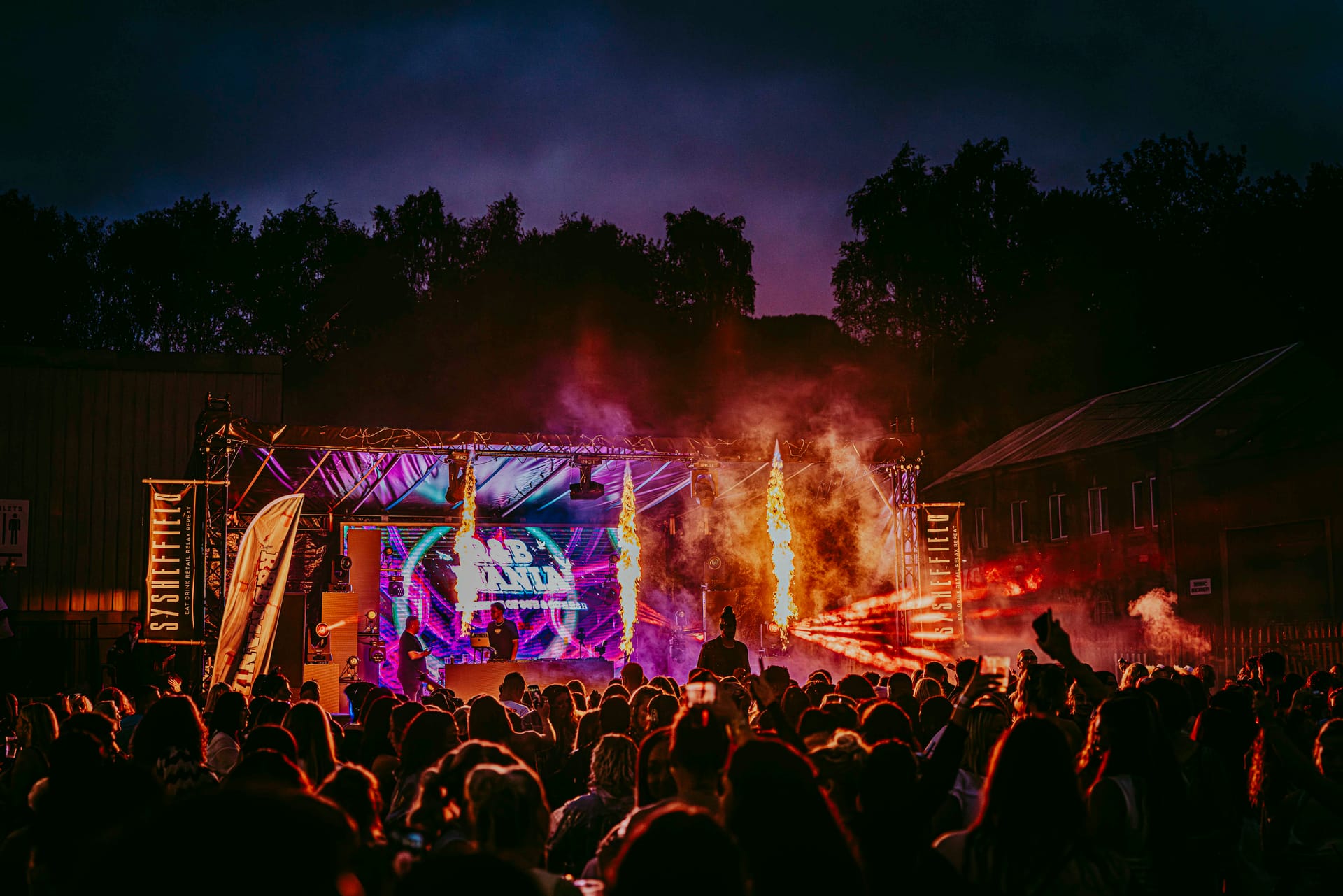 Outdoor festival stage with vibrant lights and large crowd 