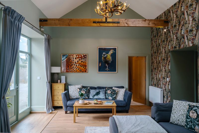 Charming living room with rustic beams, elegant sofa, and nature-themed decor