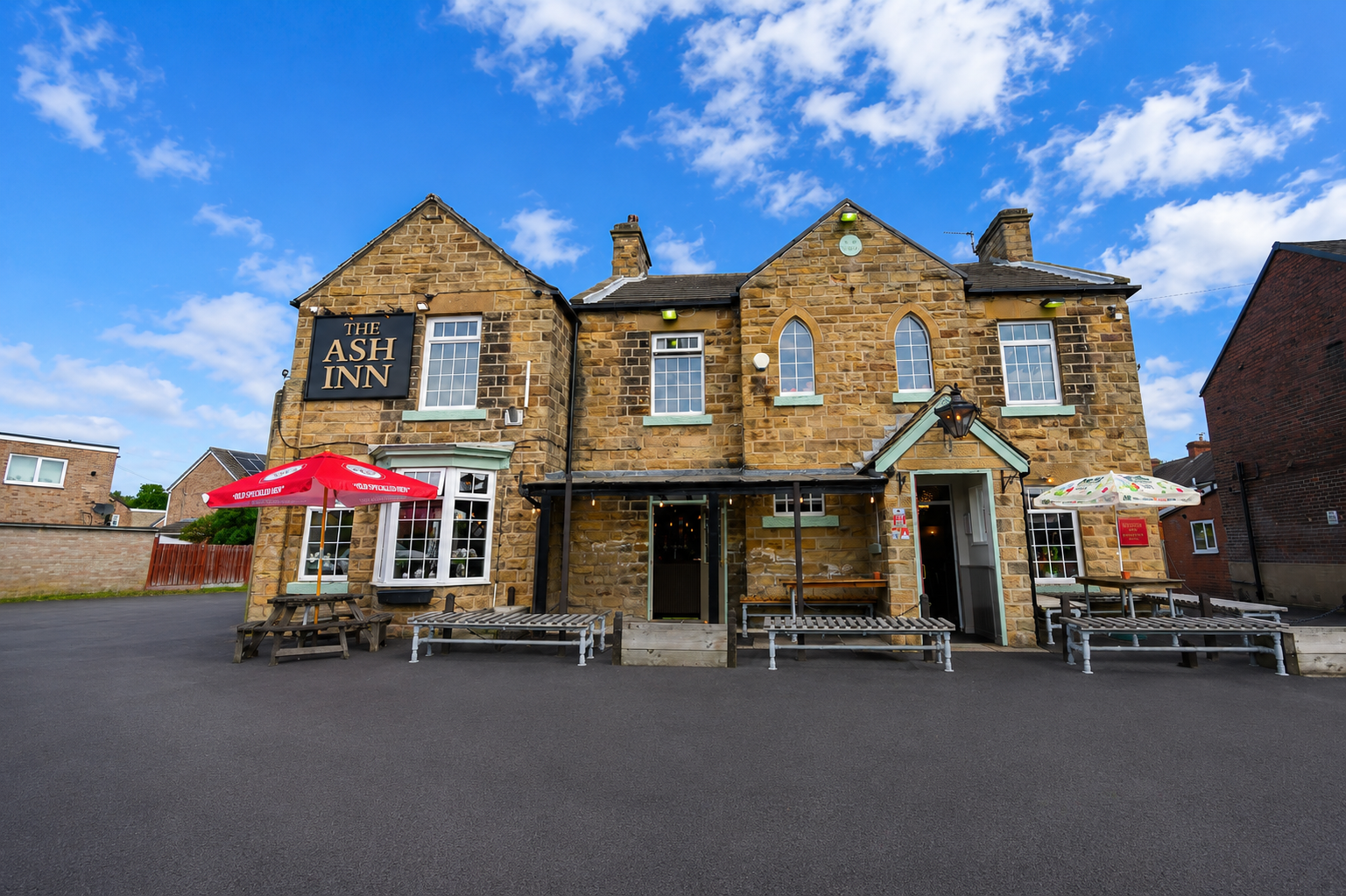 Charming stone pub exterior with outdoor seating and large beer garden to the rear