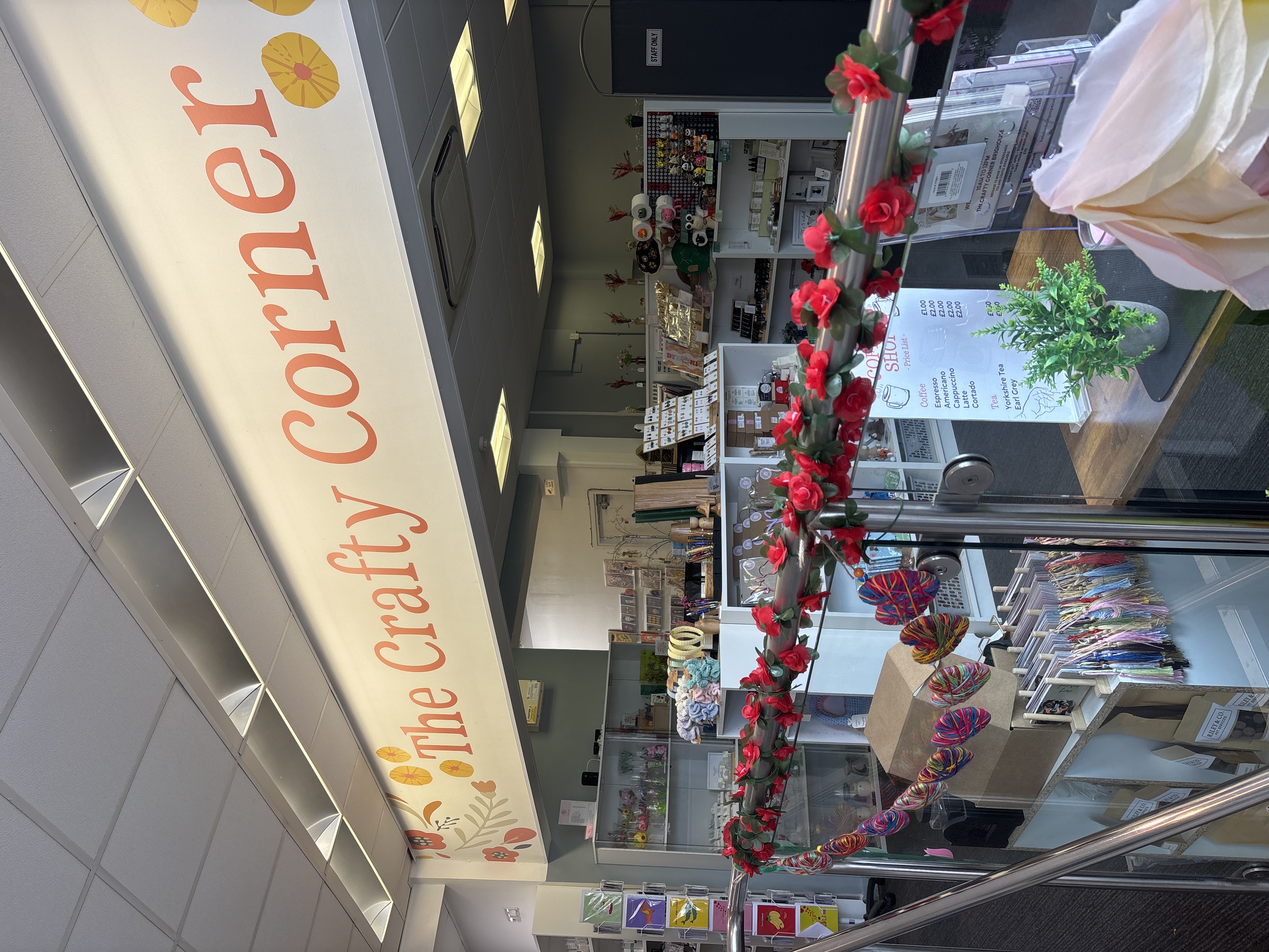 Craft shop interior with colorful crafts, signage, and floral decorations
