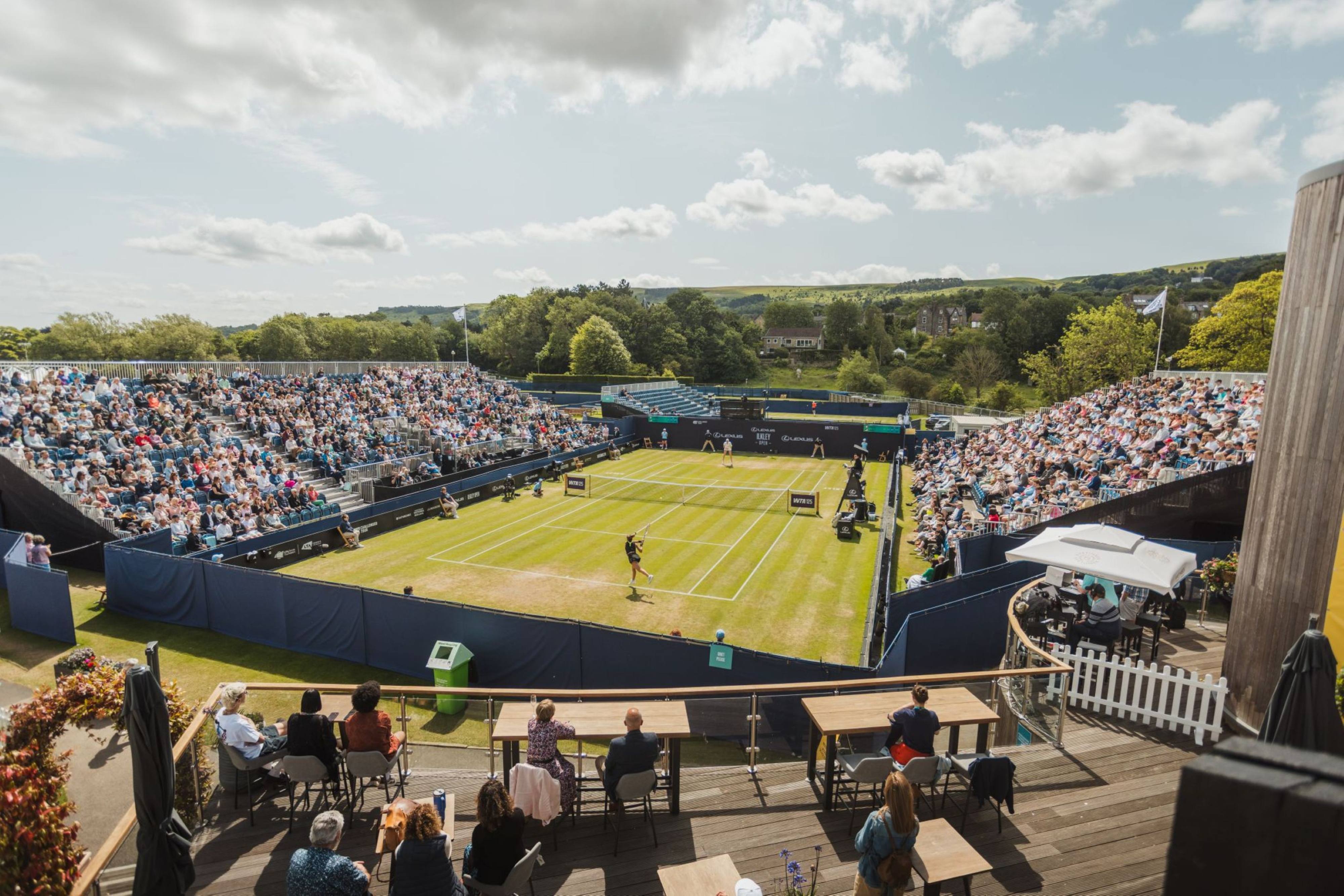 Outdoor tennis court with spectators in a scenic Yorkshire setting