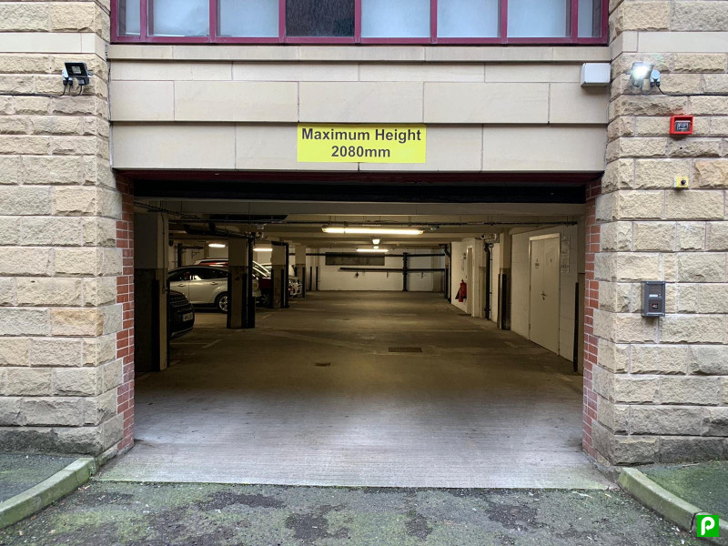 Pay & Display parking entrance with a sign indicating maximum height of 2080mm and empty parking spaces inside.