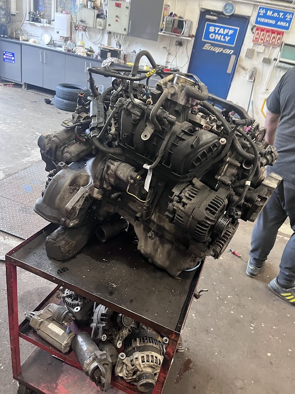Engine on a workbench in a garage, with tools and equipment visible in the background.