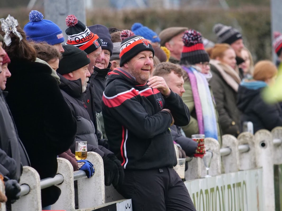 Crowd of spectators wearing hats and coats, enjoying a rugby match at Malton & Norton RUFC in Old Malton.