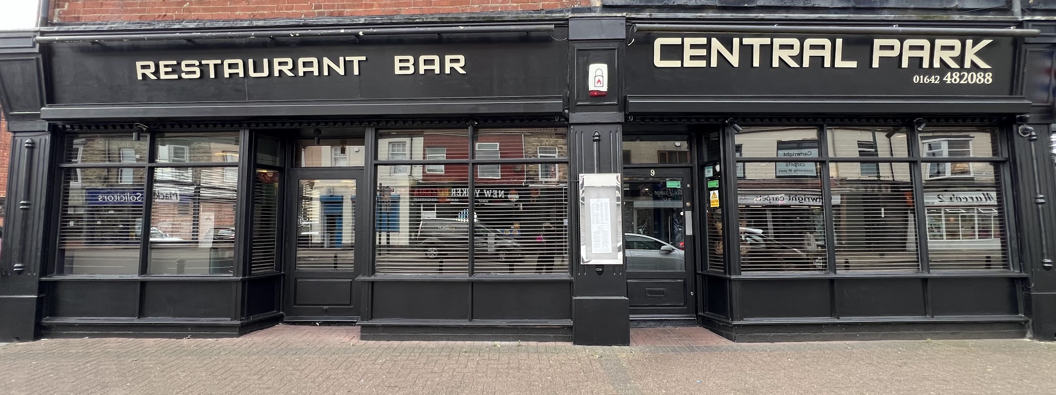 Black storefront with large windows, featuring "CENTRAL PARK" and "RESTAURANT BAR" signage.