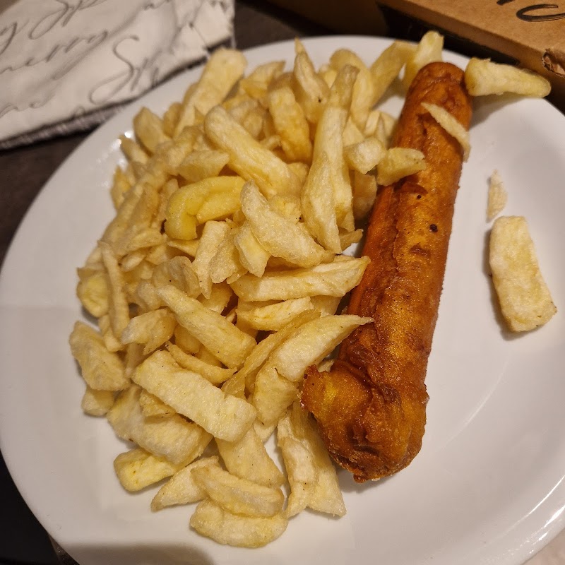 Plate of golden, crispy chips with a single battered fish fillet, served at Fish & Chippery in Skipsea, Yorkshire.