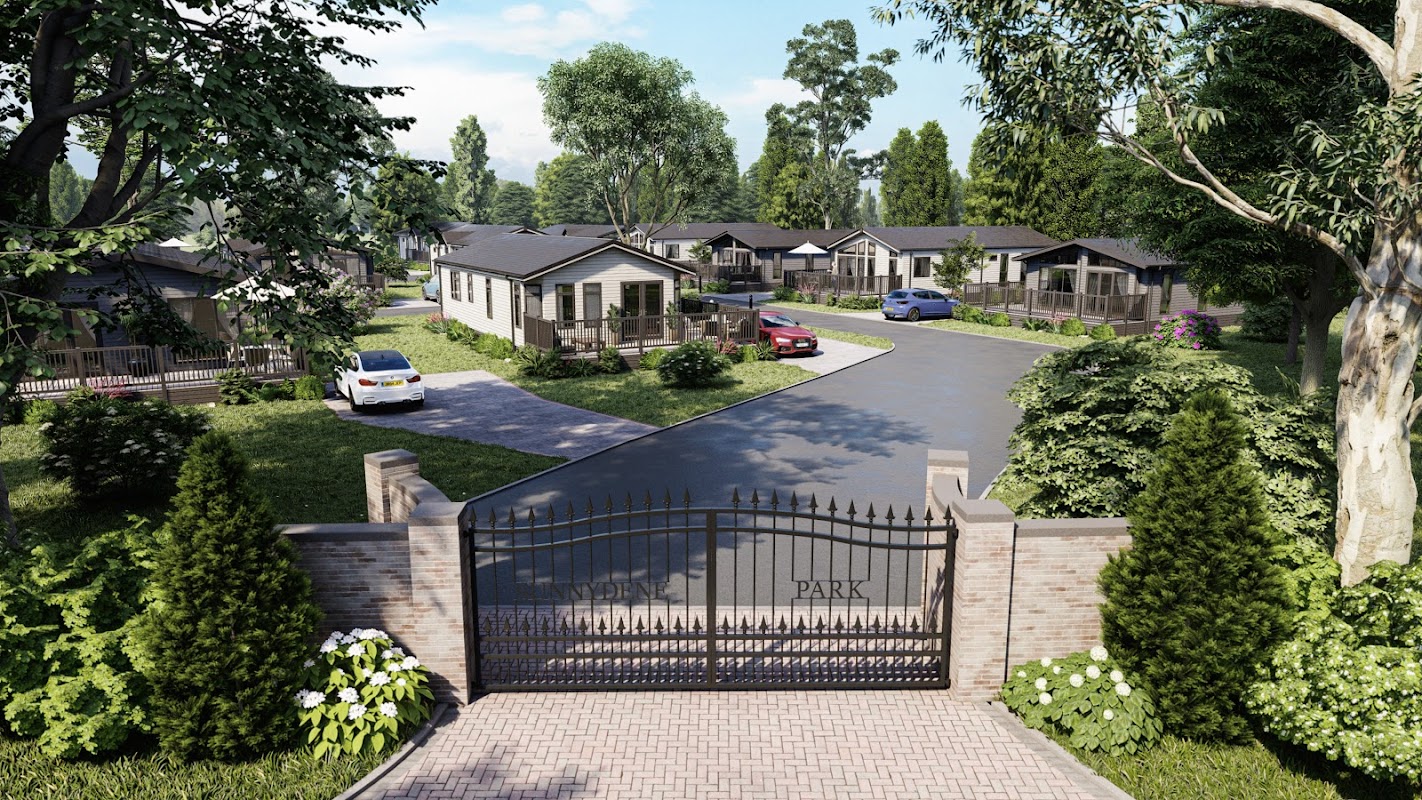 Gated entrance to Sunnydene Country Park, featuring modern lodges, landscaped greenery, and parked cars along a winding road.