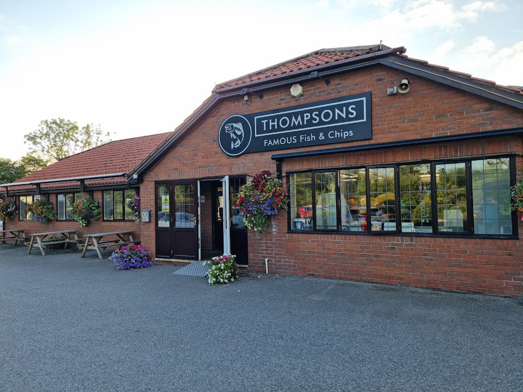 Thompsons Famous Fish & Chips restaurant with a brick exterior, flower baskets, and outdoor seating in Stockton on the Forest.