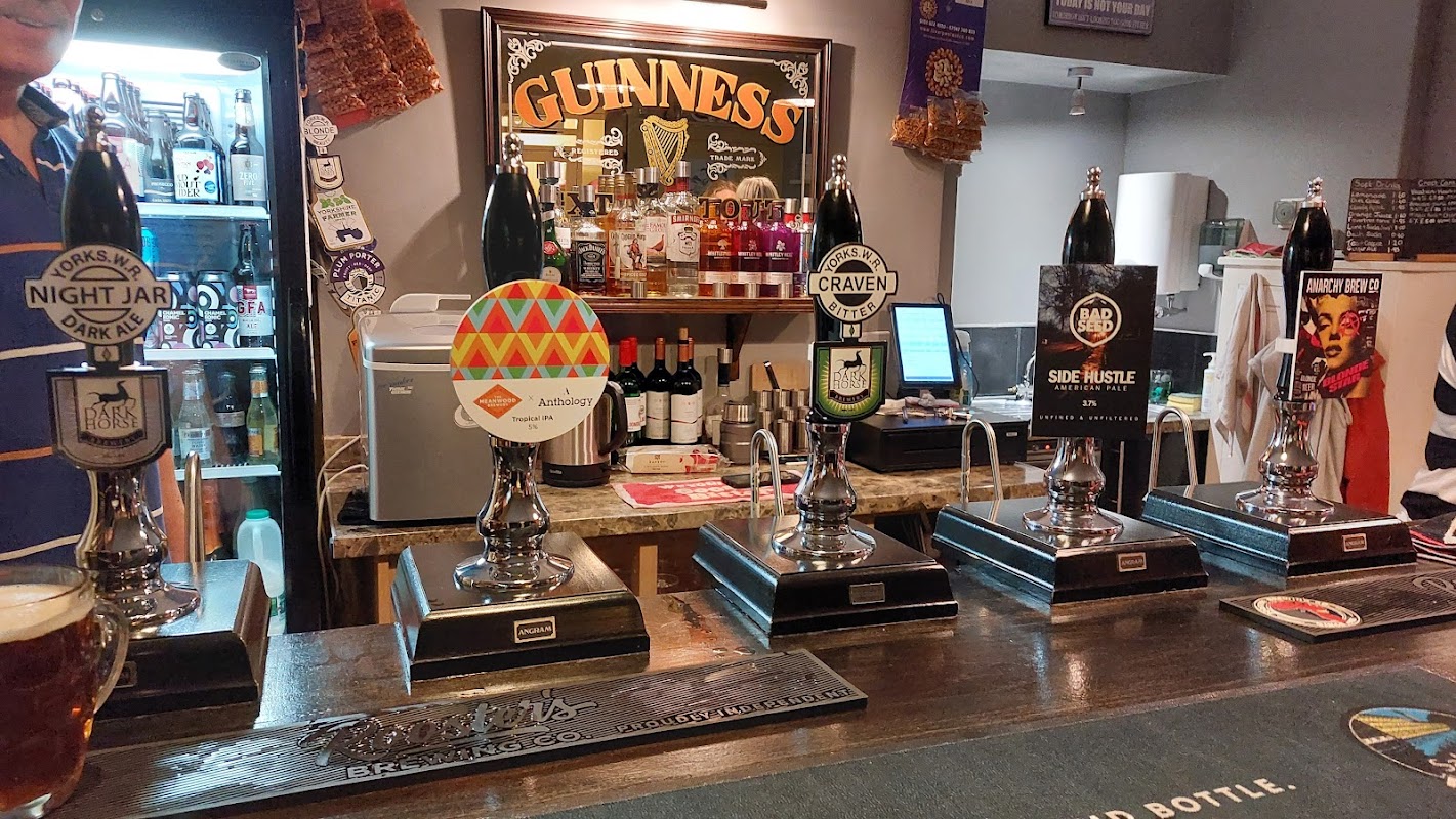 Bar interior featuring five beer taps, a selection of bottles, and a sign for Gallagher's Ale House.