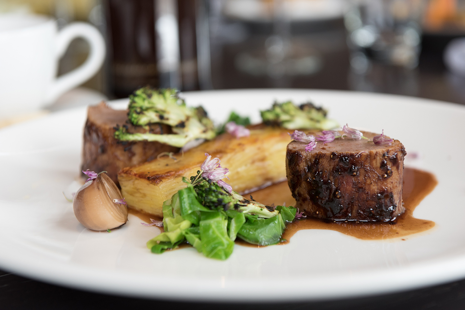 Elegant dish with two beef medallions, potato gratin, and garnished vegetables at Clevedon Restaurant, North Yorkshire.