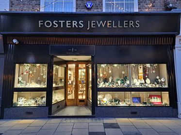 Fosters Jewellers storefront with elegant displays of jewelry and a welcoming wooden entrance in York, Yorkshire.