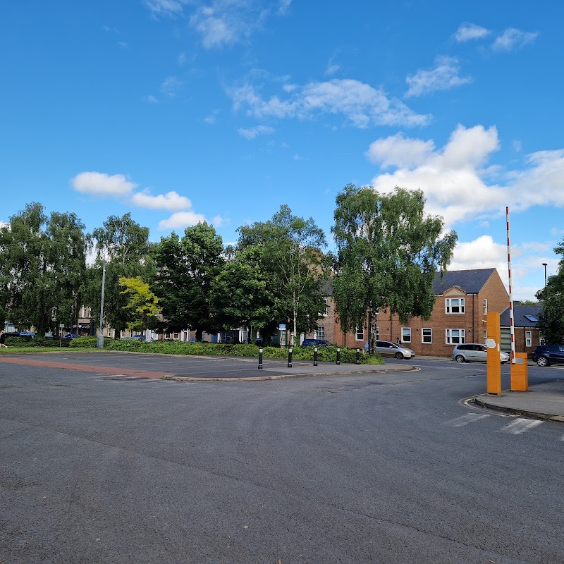 Union Terrace Car Park featuring trees, blue sky, and surrounding buildings with a barrier at the entrance.