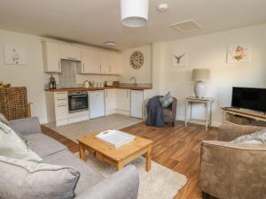 Cozy interior of The Byre cottage, Hood Grange, with modern kitchen, wooden floors, and comfortable seating.