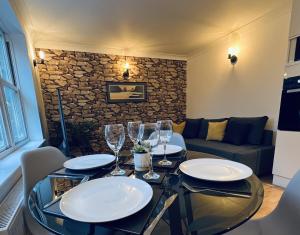 Cozy Harrogate cottage living room with stone accent wall, plush sofa, elegant dining setup, and soft ambient lighting.