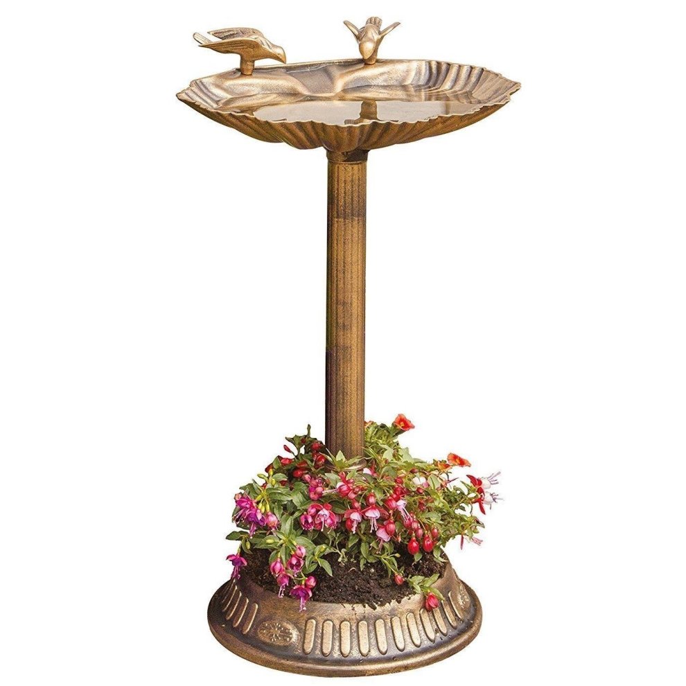 Brown clam shell outdoor bird bath with a built-in base for plants, featuring a decorative bird on the rim and vibrant flowers at the base.