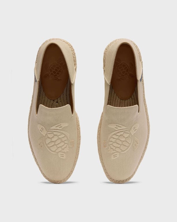 Beige canvas boat shoes by Vilebrequin, featuring a turtle logo embossed on the upper, with a textured sole, designed for men in size 44.