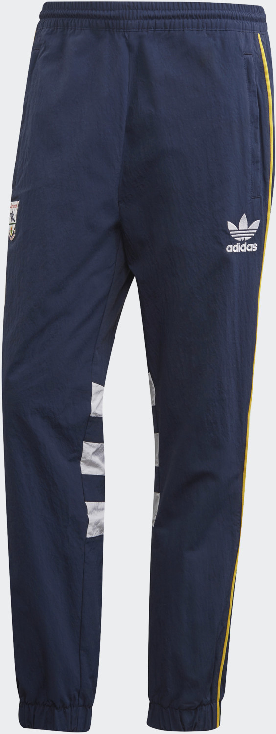 Collegiate navy tracksuit bottoms featuring the Adidas Trefoil logo, white stripes on the sides, and a comfortable elastic waistband.