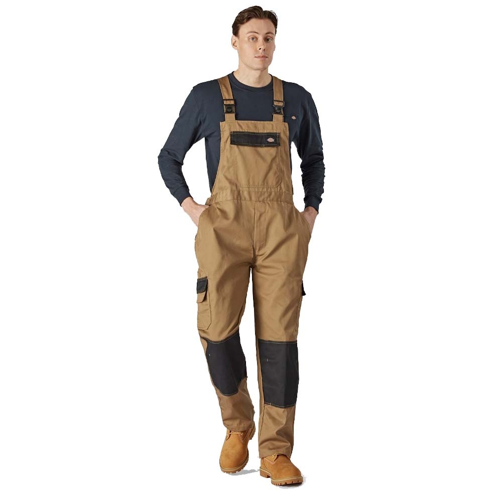 Brown polyester bib overalls with adjustable straps, multiple pockets, and black knee patches, worn by a man with a navy long-sleeve shirt and brown work boots.