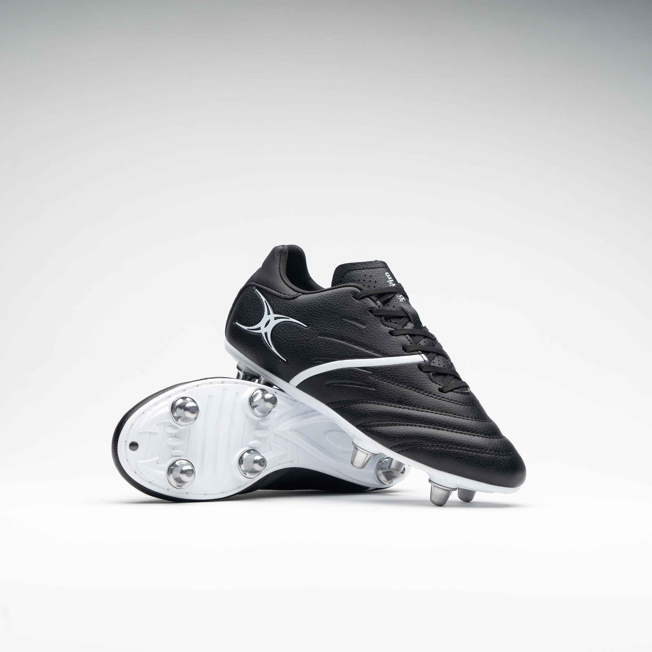 Black junior rugby boots with a sleek design, featuring a textured upper, white accents, and a durable white outsole with six metal studs for traction.