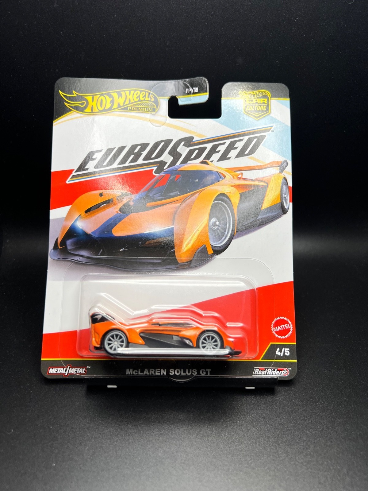 McLaren Solus GT Hot Wheels Premium car in orange and black, featuring sleek design and detailed body, displayed on a Eurospeed packaging with a vibrant red and white background.