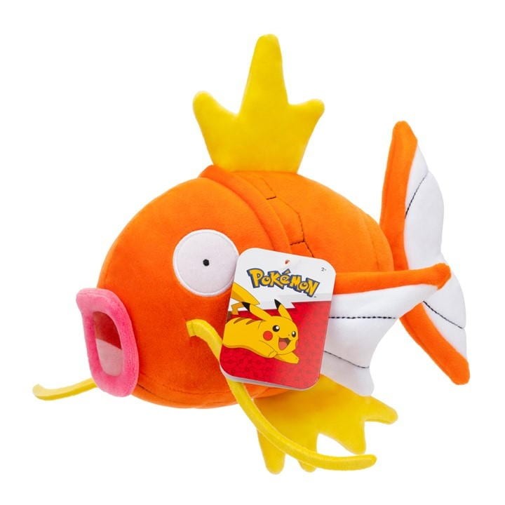Soft toy of Magikarp from Pokémon, featuring bright orange plush fabric, large eyes, pink mouth, and yellow fins, measuring 20cm with a tag showcasing Pikachu.