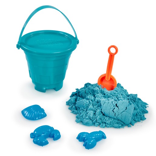 Bright turquoise plastic sand bucket with a handle, accompanied by an orange shovel and blue sand molds shaped like a crab and a shell, with a pile of soft, colorful sand.