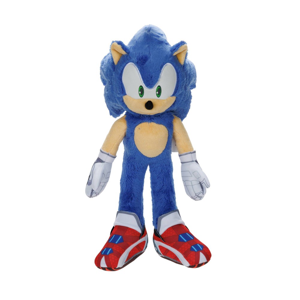 Blue plush Sonic the Hedgehog soft toy, featuring large green eyes, white gloves, and red shoes with blue accents, standing upright with a soft, fuzzy texture.