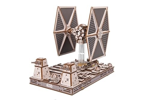 Detailed model of a TIE Fighter from Star Wars, featuring grey and brown components, large vertical wings, and a base with intricate designs and the Star Wars logo.