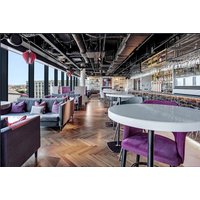 Radisson RED Sky Bar with modern seating, purple chairs, city view, and tables set for afternoon tea in Glasgow.