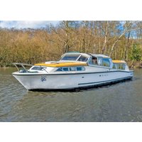 White Sovereign boat by Hoseasons with yellow accents, large windows, and sleek design cruising on a river.