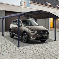 Grey metal carport with arched roof, supported by six dark posts, covering a parked car on a cobblestone driveway.