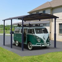 Grey metal carport with arched roof and four sturdy posts, covering a classic green van on a paved driveway.