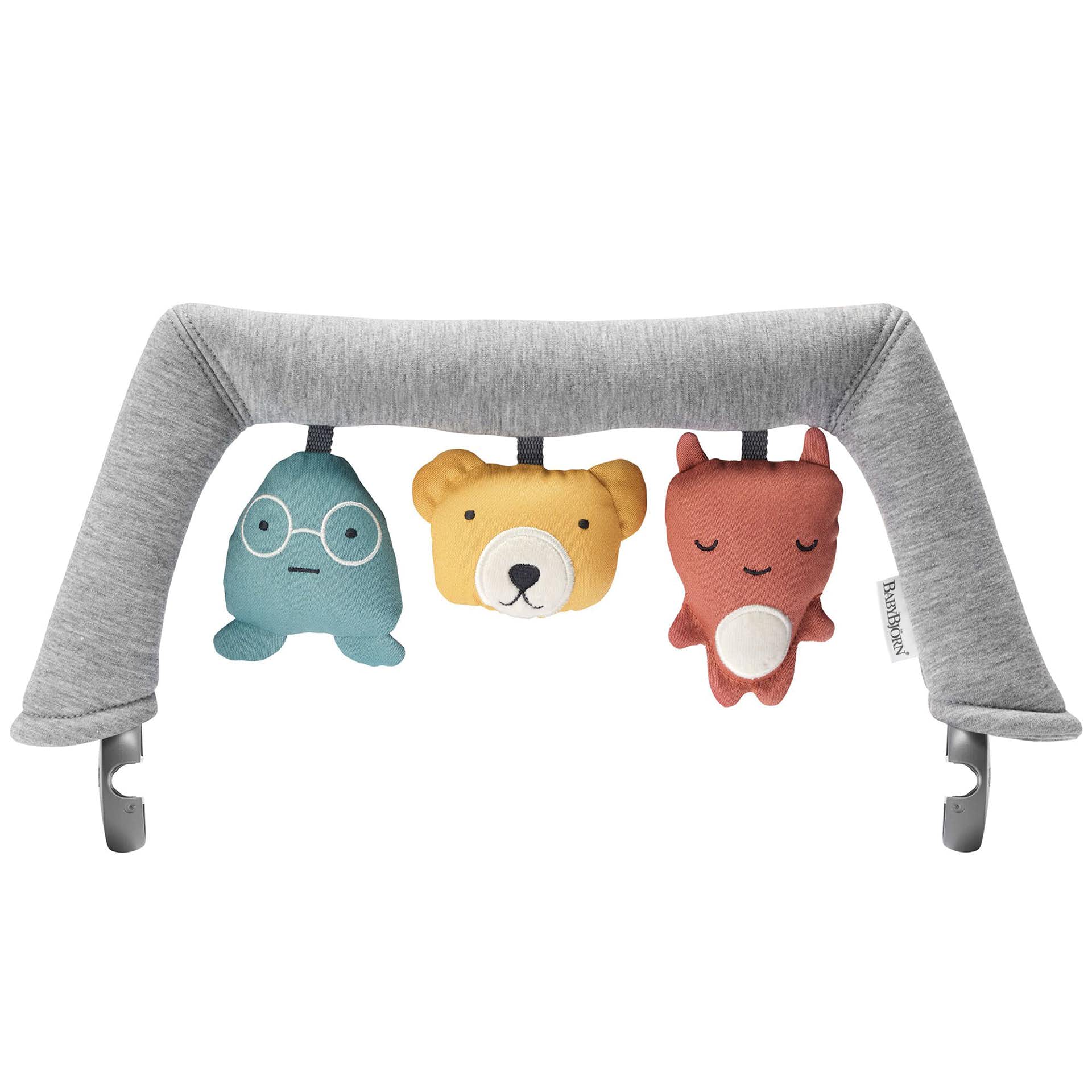 Gray fabric arch with three plush toys: a blue character with glasses, a yellow bear, and a red fox, designed for BabyBjorn bouncers.