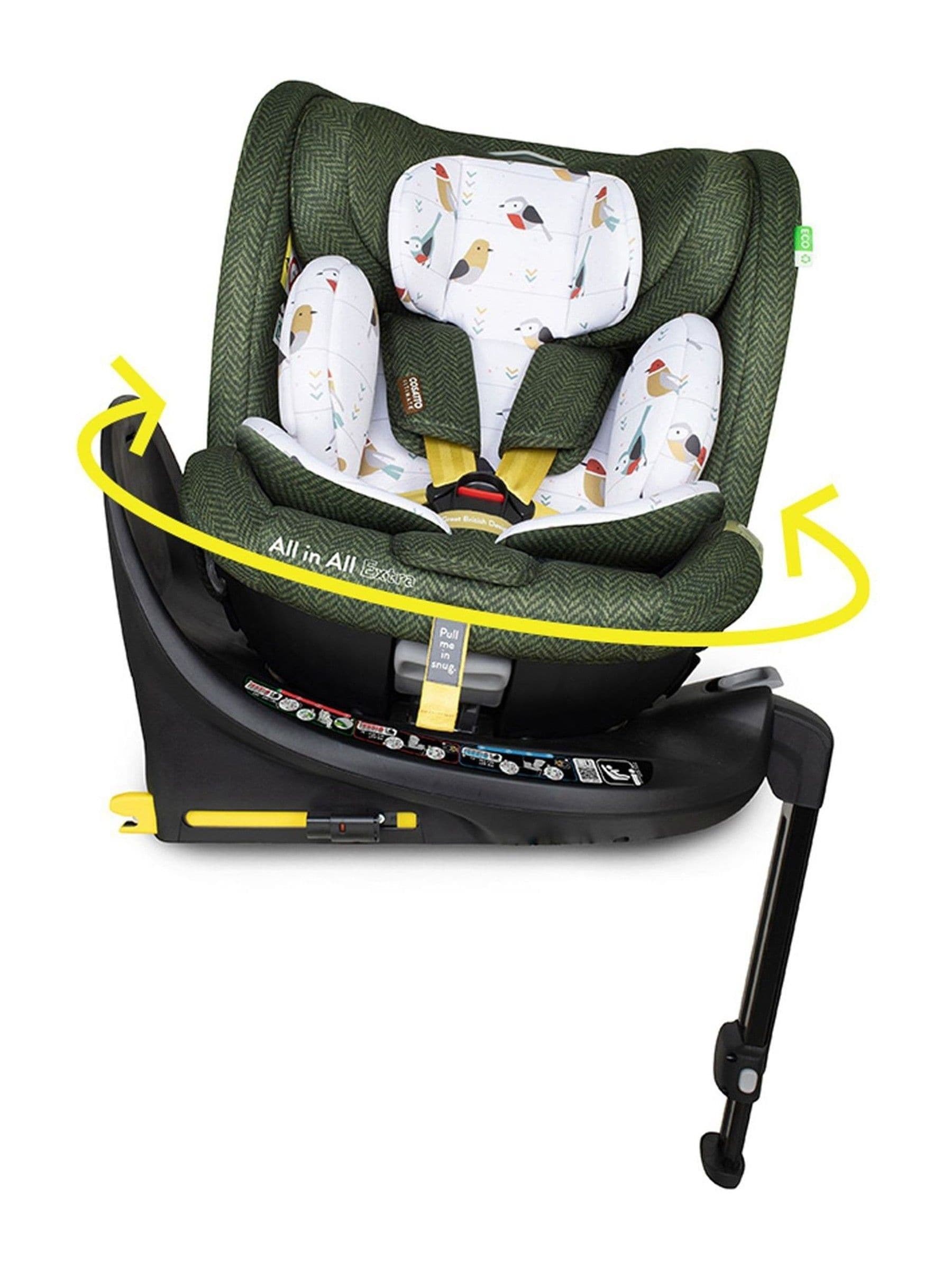 Cosatto Bureau All in All Extra I-Size 360 car seat features a green fabric with bird patterns, a rotating base, and a sturdy black base with safety stickers and a support leg.