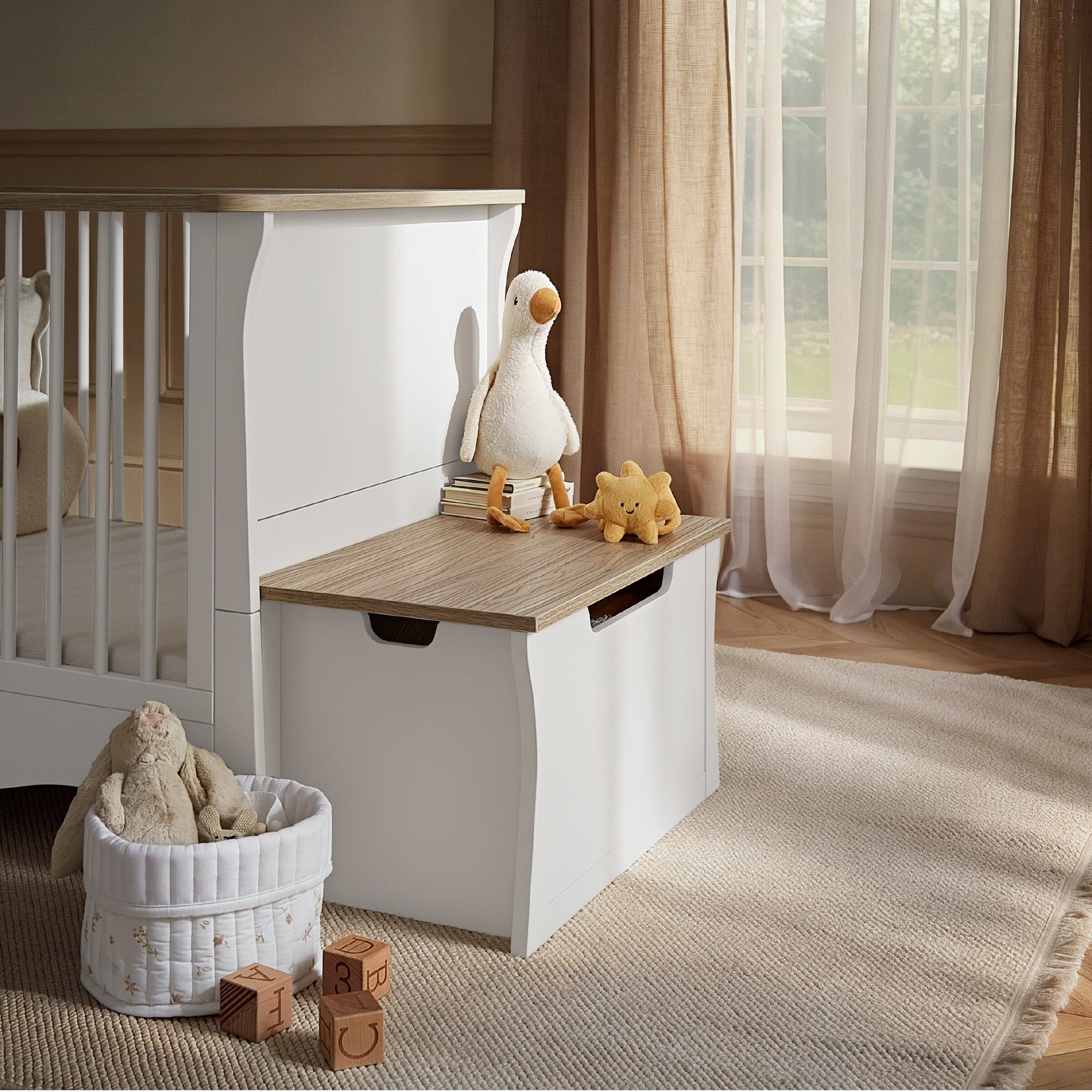 Clara Storage Box in white and ash features a sleek design with a wooden top, cut-out handles, and a spacious interior, perfect for organizing toys and nursery essentials.
