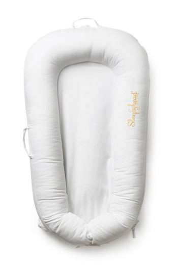 Soft, plush baby dock in pristine white with a padded, contoured design, featuring a removable cover and handles for easy transport.