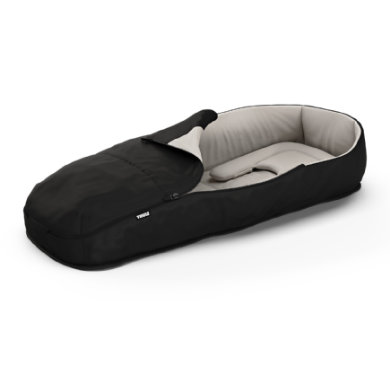 Thule Newborn Nest in black with a soft, padded interior, featuring a zippered cover for warmth and comfort, designed for infants.