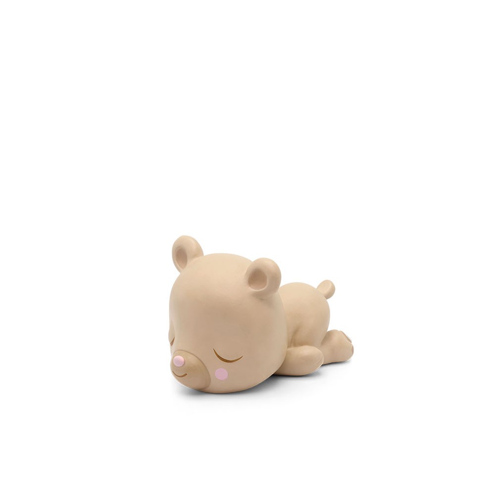 Soft beige bear character with closed eyes and pink cheeks, lying on its stomach, designed for the Tonie audio system to tell bedtime stories.