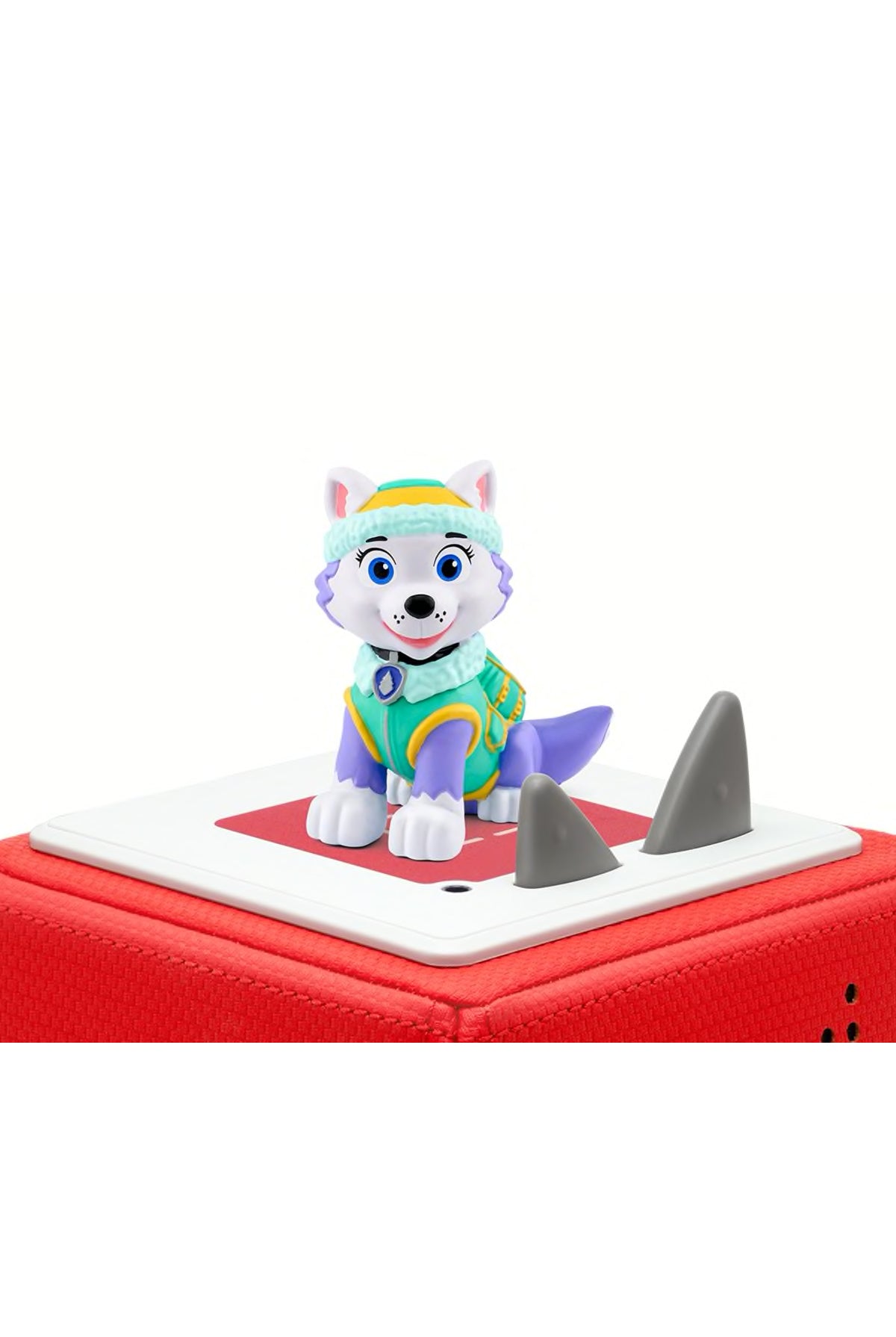 Paw Patrol Everest figure in multi-colored attire, featuring a blue and green outfit, white fur, and a playful expression, atop a red Tonies speaker with gray spikes.