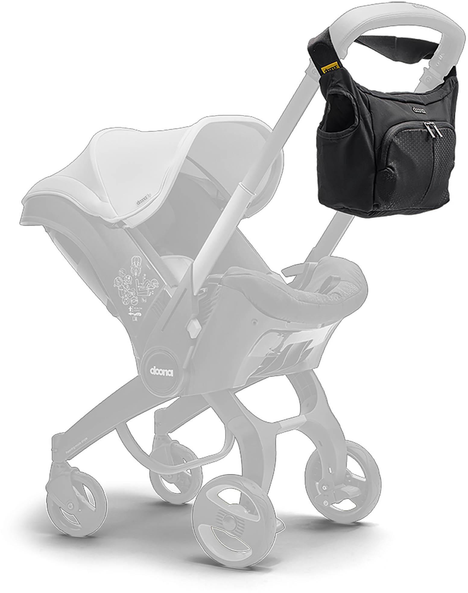 Black Doona Essentials Bag with zippered pockets, attached to stroller handle, sleek design with yellow logo tag.