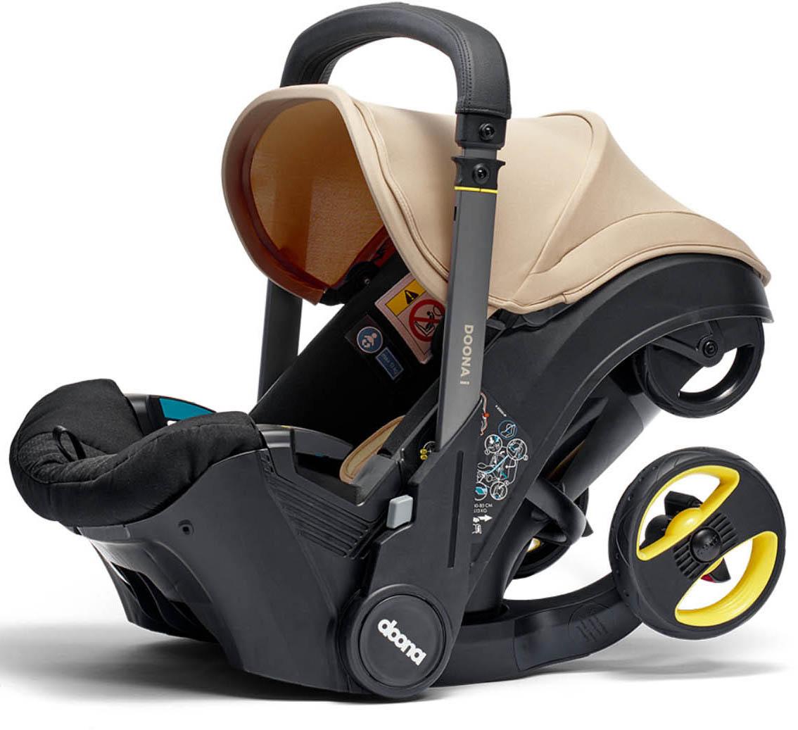 Doona i Car Seat & Stroller in Sahara Sand, black frame, beige canopy, integrated wheels, and yellow accents.