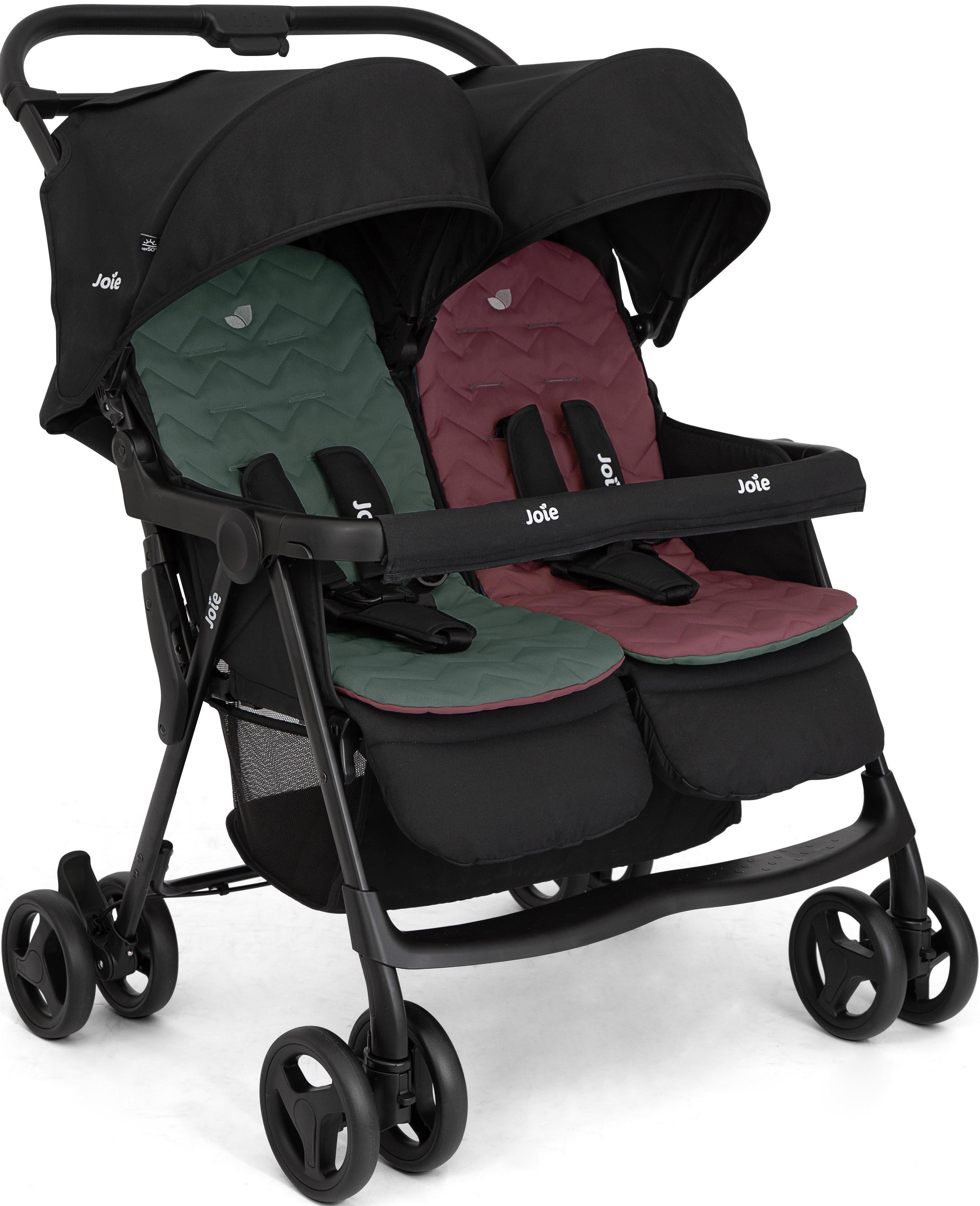 Black Joie Aire Twin stroller with green and red seats, dual canopies, and four double wheels.