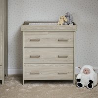 Grey wash oak changing unit with three drawers, flat top surface, and sleek handles, featuring plush toys on top.