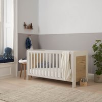 White and oak cot bed with slatted sides, distressed oak panels, and a minimalist design in a cozy nursery setting.