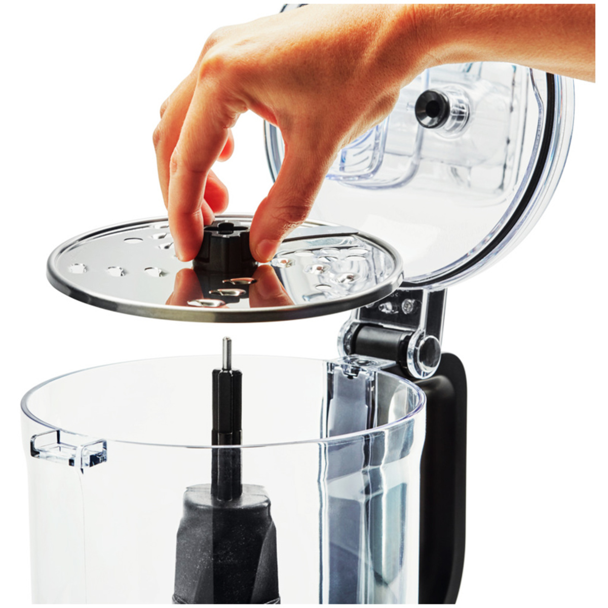 KitchenAid 5KFP0719BOB food processor in Onyx Black, featuring a clear bowl, a stainless steel lid with a feed tube, and a hand placing the lid on the bowl.