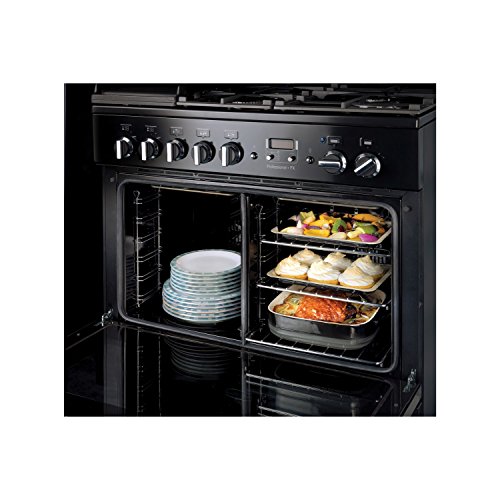 Stainless steel Rangemaster PROP90FXEISSC induction range cooker featuring multiple control knobs, a digital display, and an oven with two racks filled with dishes.