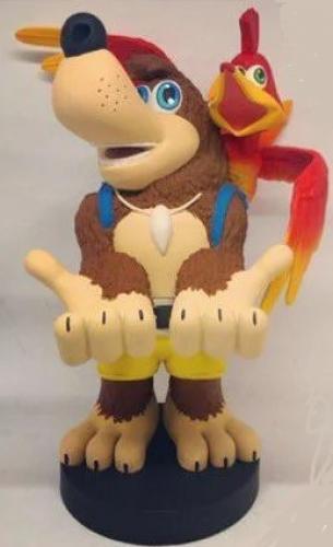 Banjo Kazooie Cable Guy features a brown bear with a friendly expression, wearing a blue vest, holding out his hands, with a red bird perched on his shoulder, set on a black base.