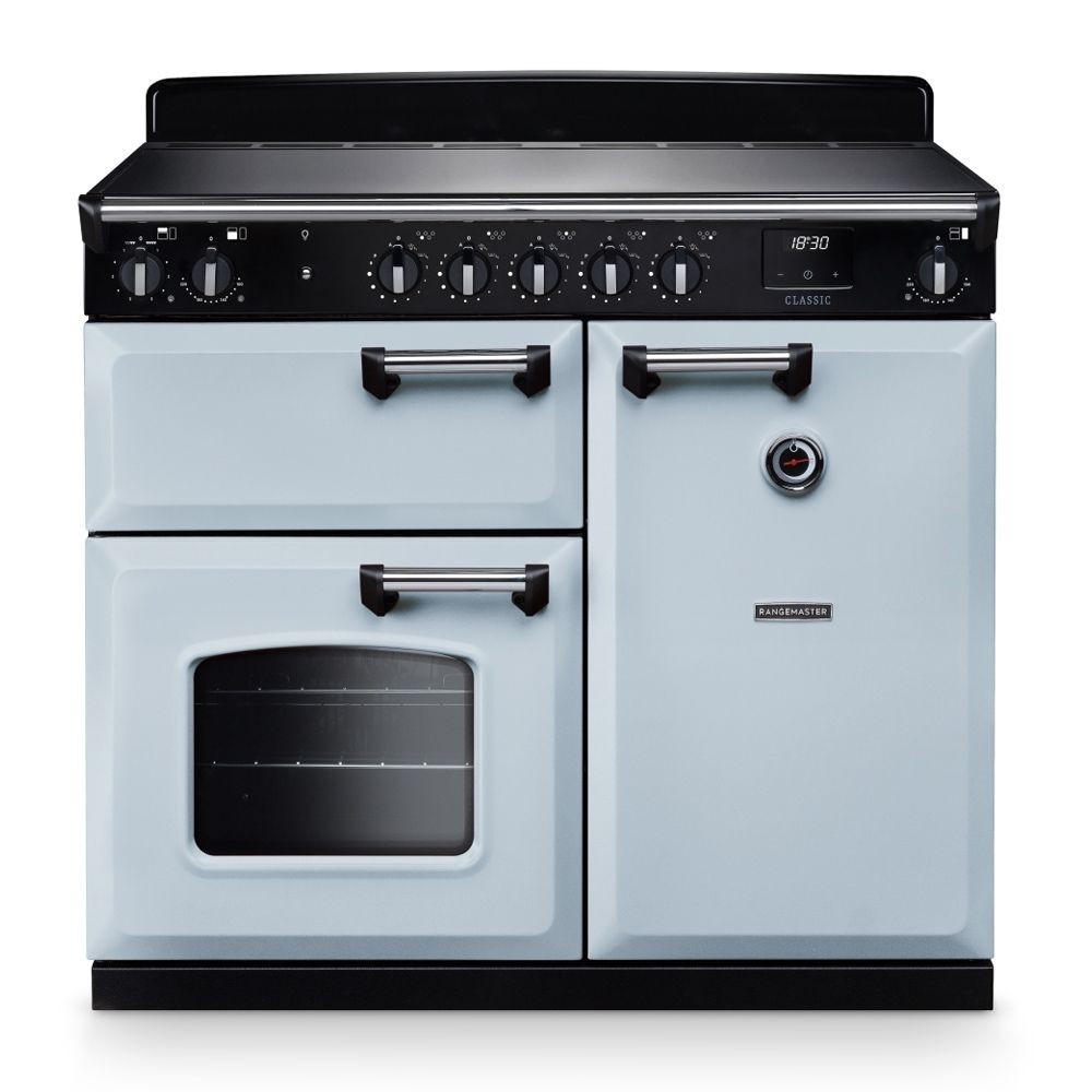 Classic 100cm induction cooker in misty blue and chrome, featuring a sleek black hob, multiple control knobs, a spacious oven with a glass window, and stylish chrome handles.