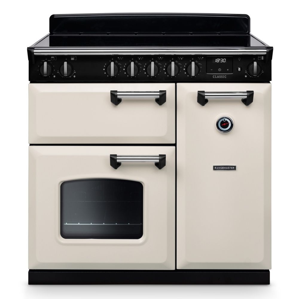 Classic 90cm induction cooker in pale cream with chrome accents, featuring a black control panel, six knobs, and a single oven with a glass window.