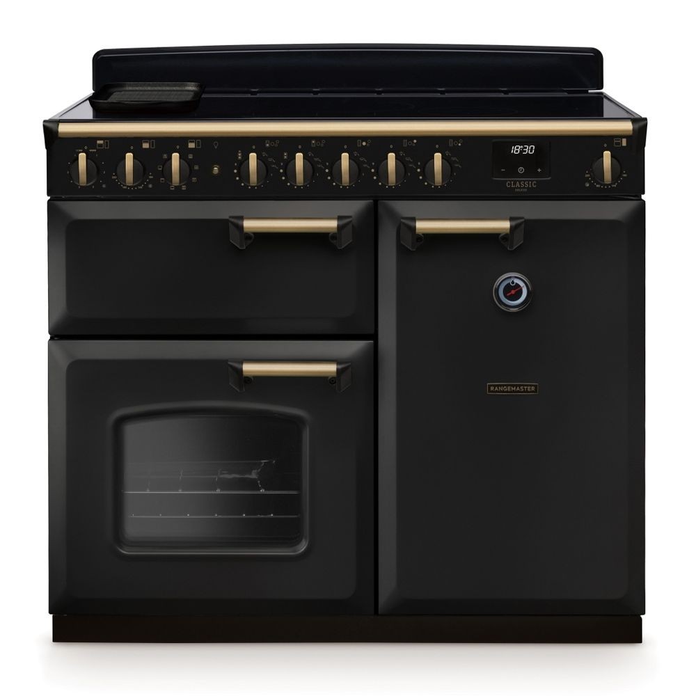 Classic Deluxe 100cm induction range cooker in charcoal black with antique brass accents, featuring six control knobs, a glass oven door, and a sleek ceramic hob.